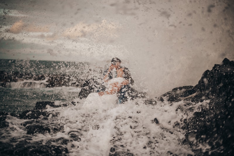 Elopement Photographer, bride and groom kiss behind the waves